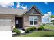 A welcoming entryway with a black front door, brick facade, and green shrubbery at 9671 Holborn Ave, McCordsville, IN 46055