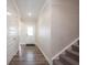 Inviting hallway with hardwood floors, white trim, and a view of the front door at 9671 Holborn Ave, McCordsville, IN 46055