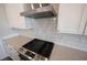 Close-up of stainless steel gas range with white subway tile backsplash and white cabinets in bright, modern kitchen at 9671 Holborn Ave, McCordsville, IN 46055