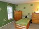 Green bedroom with a dinosaur theme and an armoire at 10042 Pine Grove Way, Indianapolis, IN 46234