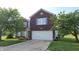 Charming brick two-story home featuring an attached garage, beautiful landscaping, and manicured front lawn at 10042 Pine Grove Way, Indianapolis, IN 46234