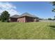 Exterior view of the brick home featuring a well-manicured lawn and screened-in porch at 1019 White Oak Dr, Plainfield, IN 46168