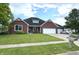 Inviting brick home with a lush green lawn, a spacious driveway, and a convenient two-car garage at 1019 White Oak Dr, Plainfield, IN 46168