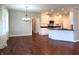Spacious room with hardwood floors, opening up to a modern kitchen with white cabinets and dark countertops at 1019 White Oak Dr, Plainfield, IN 46168