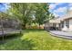 Spacious backyard with lush green grass, a trampoline, and a deck with a sunshade at 10215 Lauren Pass, Fishers, IN 46037