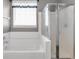 Well-lit bathroom with tub and separate glass door shower at 10215 Lauren Pass, Fishers, IN 46037