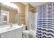 Neutral bathroom featuring a tub with blue shower curtain, white vanity, and shelving at 10215 Lauren Pass, Fishers, IN 46037