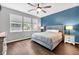 Bright bedroom features hardwood floors, a ceiling fan, and upholstered headboard at 10215 Lauren Pass, Fishers, IN 46037
