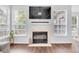 Comfortable living room with a fireplace, large windows, and hardwood floors at 10215 Lauren Pass, Fishers, IN 46037