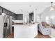 Modern kitchen features stainless steel appliances, dark cabinets and a breakfast bar overlooking the living area at 10215 Lauren Pass, Fishers, IN 46037