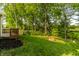Beautifully maintained backyard with lush green grass, mature trees, and a cozy fire pit at 10216 Hatherley Way, Fishers, IN 46037