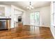 Bright dining area showcasing wood floors and a view into an adjacent living space with a stone fireplace at 10216 Hatherley Way, Fishers, IN 46037