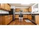 Well-equipped kitchen featuring stainless steel appliances, granite countertops, and wooden cabinetry at 10216 Hatherley Way, Fishers, IN 46037