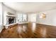 Open living room featuring a stone fireplace and hardwood floors at 10216 Hatherley Way, Fishers, IN 46037