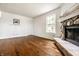 Bright living room featuring hardwood floors, a stone fireplace, and natural light at 10216 Hatherley Way, Fishers, IN 46037