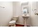 Cozy powder room with a pedestal sink and classic fixtures at 10216 Hatherley Way, Fishers, IN 46037