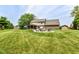 Expansive backyard features a well-manicured lawn, fire pit, pergola, shed, and mature trees at 1031 W Morning Walk Dr, Greenfield, IN 46140