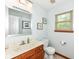 Powder room with wood vanity, marble countertop, framed mirror and window providing natural light at 1031 W Morning Walk Dr, Greenfield, IN 46140