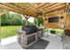 Covered outdoor kitchen with built-in grill, refrigerator, granite countertops, and a ceiling fan at 1031 W Morning Walk Dr, Greenfield, IN 46140