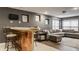 A basement living area features a sectional couch, decorative pillows, an ottoman, and a bar at 10380 Sand Creek Blvd, Fishers, IN 46037