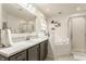 Bathroom featuring a marble countertop, grey vanity, and a tub with a shower in the background at 10380 Sand Creek Blvd, Fishers, IN 46037
