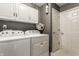 A bright laundry room features a gray wall, white cabinets and new, front-load machines at 10380 Sand Creek Blvd, Fishers, IN 46037