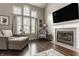 Bright living room with large windows, fireplace, hardwood floors, and comfortable lounge seating at 10380 Sand Creek Blvd, Fishers, IN 46037