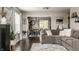 Open living room featuring hardwood floors, large sectional sofa, and a view into the dining area at 10380 Sand Creek Blvd, Fishers, IN 46037