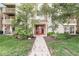 Inviting condo entrance featuring well-maintained landscaping, red door, and a welcoming pathway at 1044 Timber Creek Dr # 2, Carmel, IN 46032