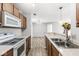 Kitchen with white appliances, wood cabinets, and wood grain laminate flooring at 1044 Timber Creek Dr # 2, Carmel, IN 46032