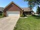 Charming brick home with a well-manicured lawn, mature trees, and a two-car garage at 10976 Mt Vernon N Trl, Indianapolis, IN 46229