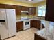 Traditional kitchen features oak cabinets, neutral countertops, and white appliances at 10976 Mt Vernon N Trl, Indianapolis, IN 46229