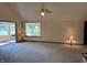 Open living room featuring a vaulted ceiling, carpet flooring, and access to the kitchen and sunroom at 10976 Mt Vernon N Trl, Indianapolis, IN 46229