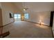 A spacious living room with vaulted ceilings, carpet flooring, and access to the kitchen and sunroom at 10976 Mt Vernon N Trl, Indianapolis, IN 46229
