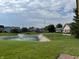 Backyard view of a pond with a fountain feature and surrounding grassy area at 10976 Mt Vernon N Trl, Indianapolis, IN 46229
