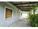 The back porch has concrete flooring with overgrown foliage at 1120 W 5Th St, Greenfield, IN 46140