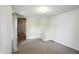 An open doorway leads to a carpeted bedroom with neutral walls and a single window at 1120 W 5Th St, Greenfield, IN 46140