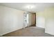 This well-lit bedroom includes neutral walls, carpet, and a view into the hallway at 1120 W 5Th St, Greenfield, IN 46140