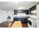 Bright kitchen with black cabinets, laminate counters, and view to the adjacent living area at 1120 W 5Th St, Greenfield, IN 46140