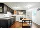 Well-lit kitchen featuring dark cabinets, white appliances, and a butcher block island, perfect for cooking and entertaining at 1120 W 5Th St, Greenfield, IN 46140