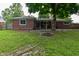 Backyard view with a brick house, patio, and a fire pit area for gatherings at 11522 Newport Dr, Indianapolis, IN 46236