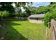 Backyard view with a storage shed surrounded by a wooden fence and lush greenery at 11522 Newport Dr, Indianapolis, IN 46236