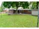 Wide view of the backyard featuring a patio, shed, and ample green space at 11522 Newport Dr, Indianapolis, IN 46236