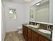 Bathroom featuring double sinks with a granite countertop, a large mirror, and tiled floors at 11522 Newport Dr, Indianapolis, IN 46236