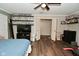 Spacious bedroom featuring wood floors, a ceiling fan, and built-in shelving for collectibles at 11522 Newport Dr, Indianapolis, IN 46236