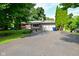 Charming single-story brick home with a spacious driveway and mature trees in a serene neighborhood at 11522 Newport Dr, Indianapolis, IN 46236