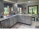Updated kitchen with gray cabinets, stainless steel dishwasher, and granite countertops with a view to dining area at 1165 Tewksbury Ct, Mooresville, IN 46158