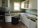 Functional kitchen with white cabinets, sink, and a window offering natural light at 121 School St, Greenfield, IN 46140