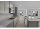 Modern kitchen with gray cabinets, stainless steel appliances, quartz countertops, and sleek finishes, offering a stylish cooking space at 12490 Morning Ridge Way, Noblesville, IN 46060