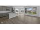 Open-concept kitchen and living area with large windows, modern finishes, and hardwood floors, creating a bright atmosphere at 12490 Morning Ridge Way, Noblesville, IN 46060